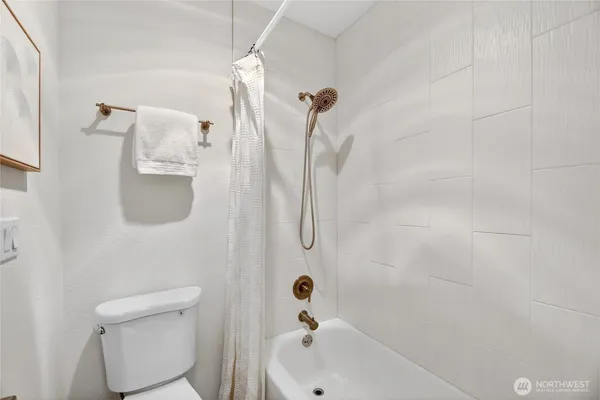 a bathroom with a shower a toilet and a shower
