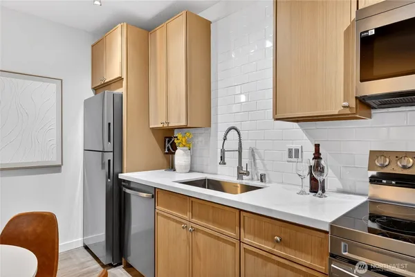 a kitchen with sink a refrigerator and cabinets