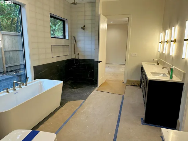 a bathroom with a tub sink and mirror