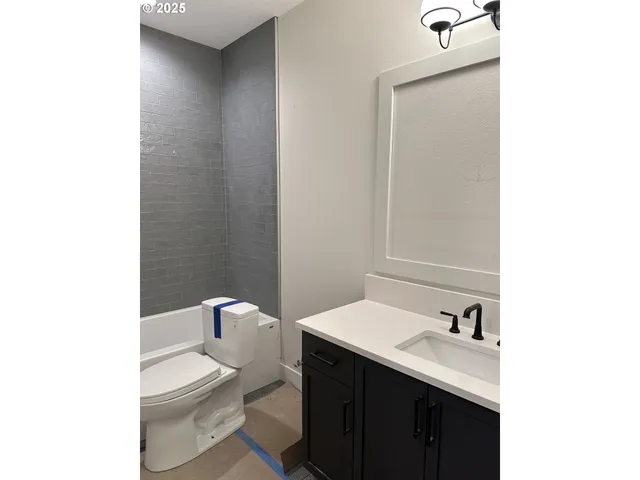 a bathroom with a sink a toilet and a mirror