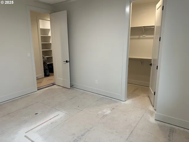 an empty room with closet and windows
