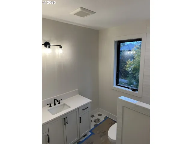 a bathroom with a toilet sink vanity and mirror