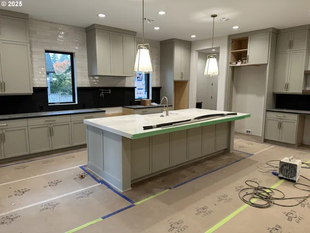 a large kitchen with kitchen island a sink stainless steel appliances and cabinets