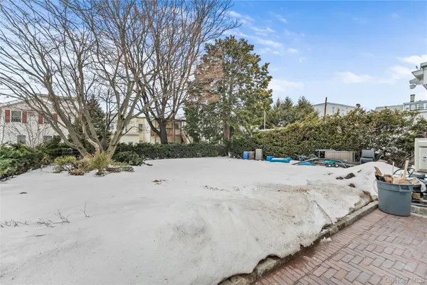 a view of white house with a yard covered in snow