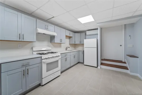 a kitchen with white cabinets and white appliances