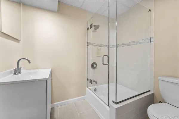 a bathroom with a shower sink mirror and toilet
