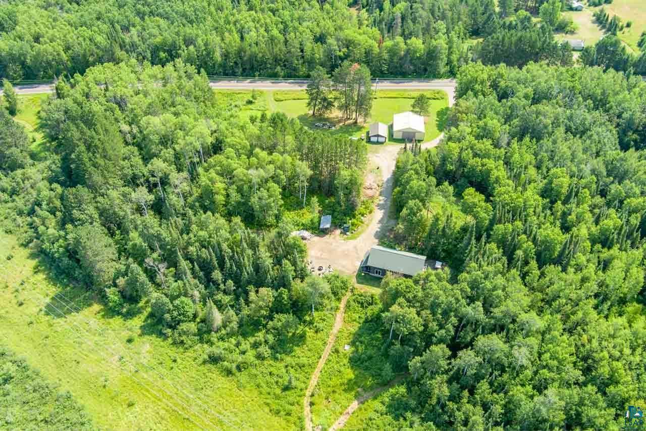 7603 Levander Road Embarrass, MN 55732 - Photo 48 of 51 Extensive wooded lot with multiple structures, including a primary residence with a green roof, a detached garage, and an additional outbuilding