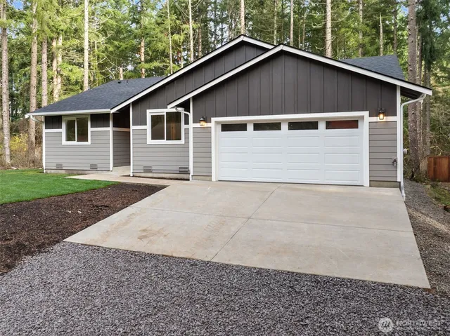 a house with white door of garage next to a yard
