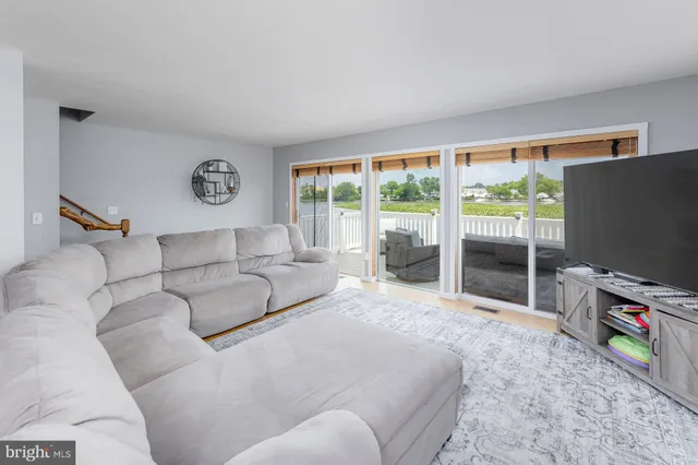 a living room with furniture a flat screen tv and a floor to ceiling window