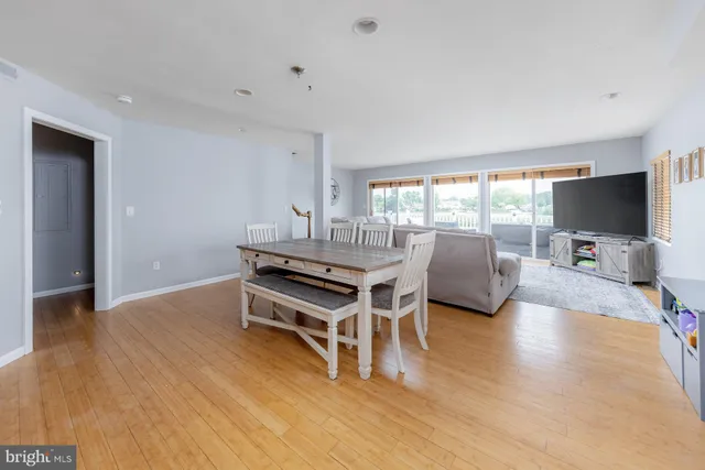 a living room with furniture a flat screen tv and wooden floor