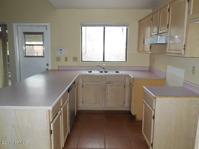170 East Guadalupe Road, Unit 148 Gilbert, AZ 85234 - Photo 4 of 29 a kitchen with a sink stove and cabinets