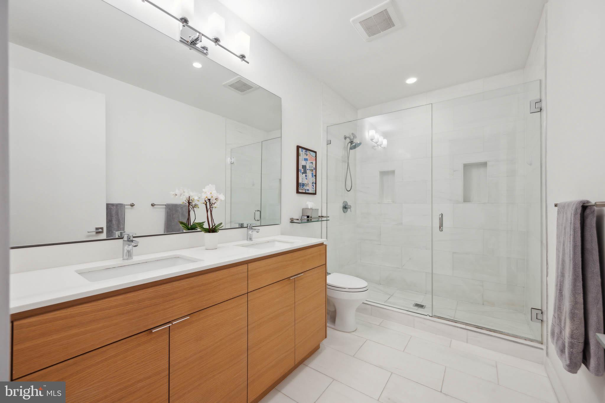 1325 Constitution Avenue Northeast Washington, DC 20002 - Photo 19 of 36 a bathroom with a double vanity sink toilet and shower