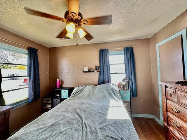 a bedroom with a bed and a flat tv screen on dresser