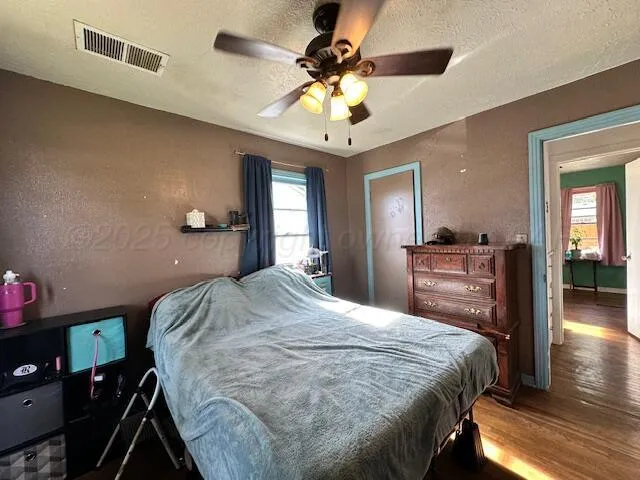 a spacious bedroom with a bed and a chandelier