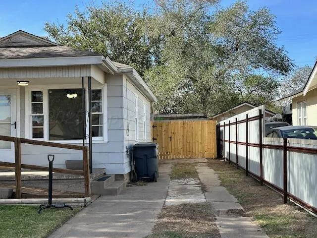 a view of a house with a large window and wooden fence