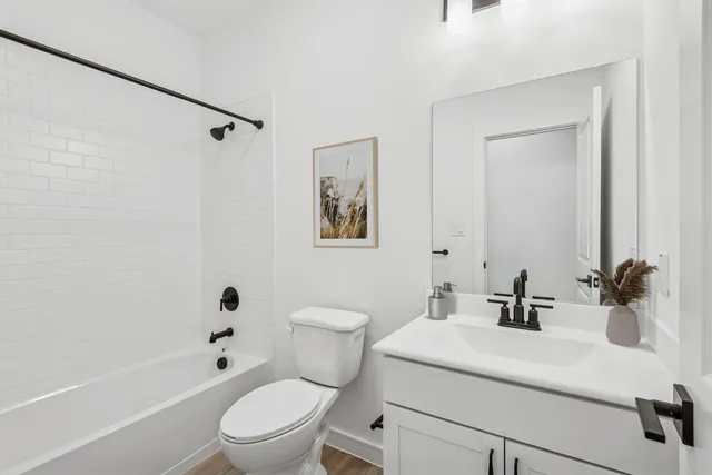 a bathroom with a sink a toilet a mirror and shower