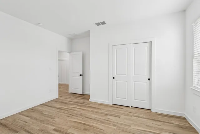 a view of a room with wooden floor and white doors