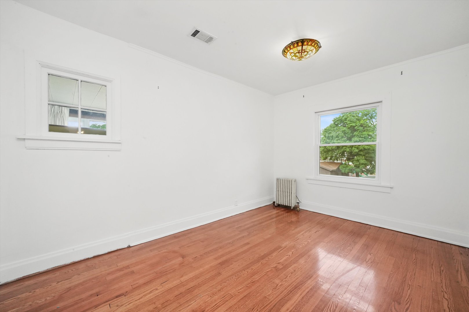 6822 34th Street Berwyn, IL 60402 - Photo 19 of 35 a view of an empty room with wooden floor and a window