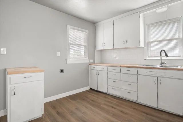 a kitchen with granite countertop white cabinets and a sink