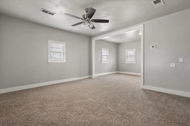 a view of a livingroom with a ceiling fan and window