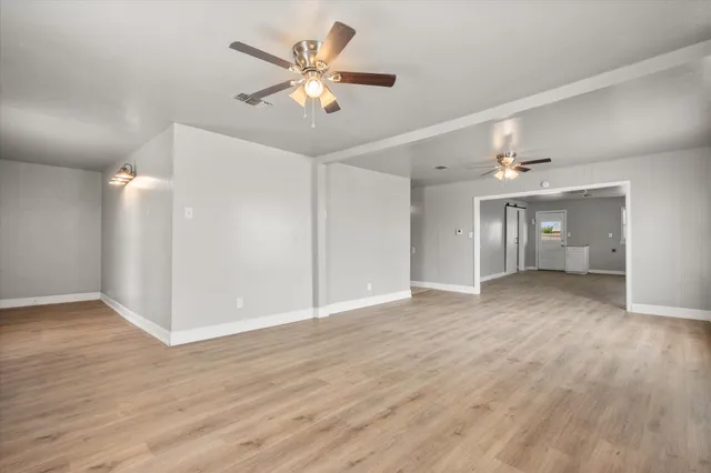 a view of an empty room with wooden floor
