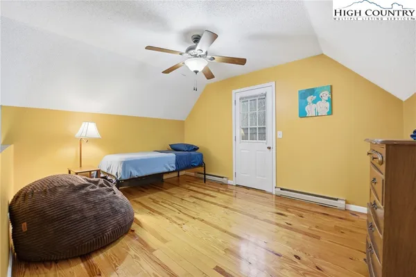 a view of a bedroom with a bed and wooden floor