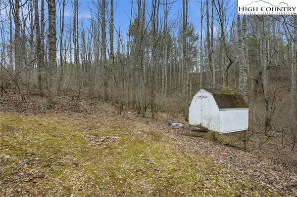 a view of a dry yard with a wooden fence