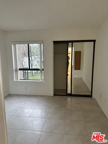 an empty room with windows and closet