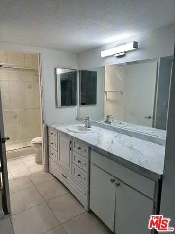 a spacious bathroom with a granite countertop sink mirror and toilet