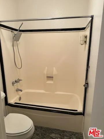 a bathroom with a toilet and a shower