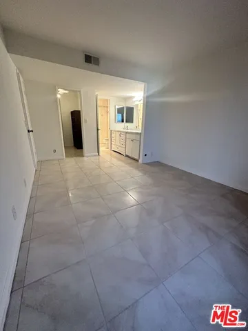 a view of an empty room with a fireplace and cabinets