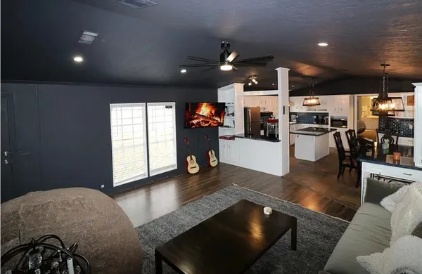 a living room with furniture and kitchen view