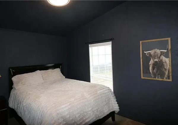 a large bed sitting in a bedroom next to a window