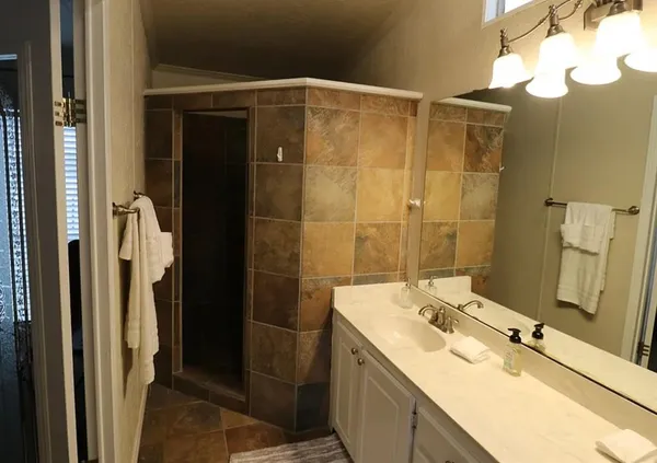 a bathroom with a shower sink and mirror