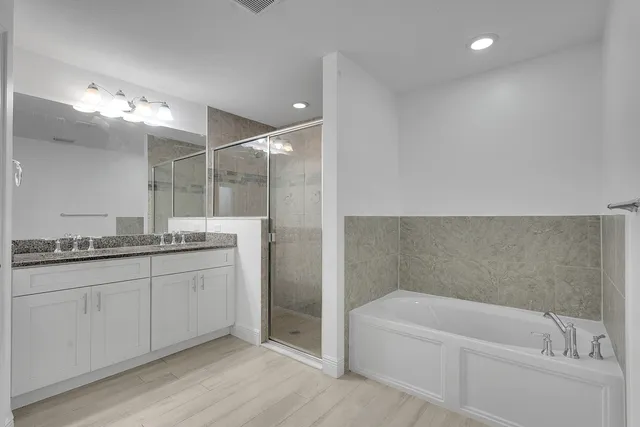 a bathroom with a granite countertop sink a toilet and bathtub