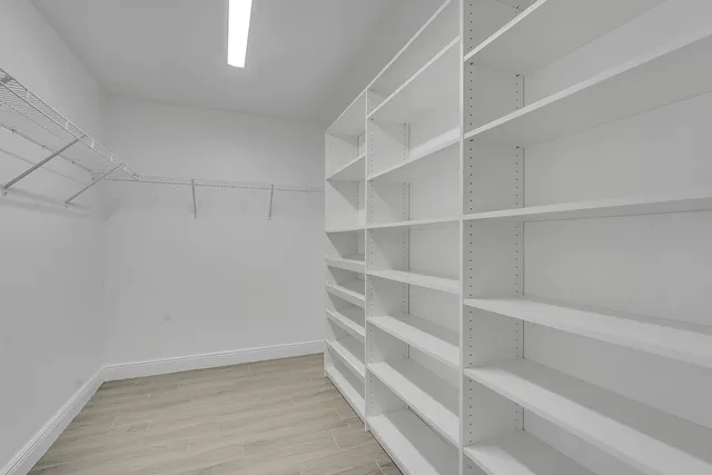 a view of walk in closet with empty racks