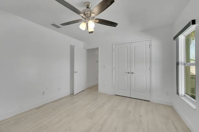 an empty room with chandelier fan