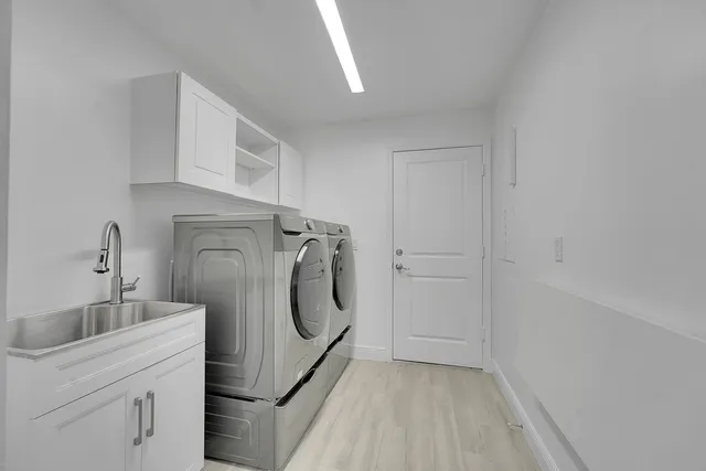a utility room with cabinets washer and dryer