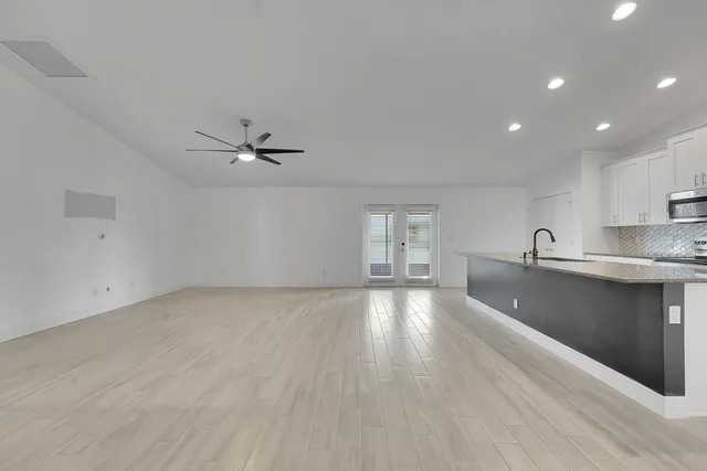 a view of a kitchen counter space a sink wooden floor and a window