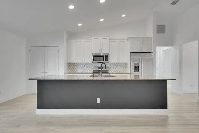 a kitchen with a sink stainless steel appliances and cabinets