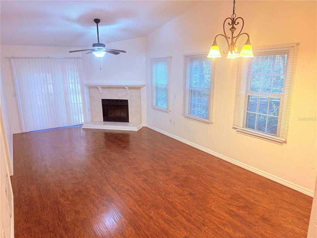 5134 Southwest 92nd Court Gainesville, FL 32608 - Photo 11 of 20 a view of an empty room with wooden floor fireplace and a window