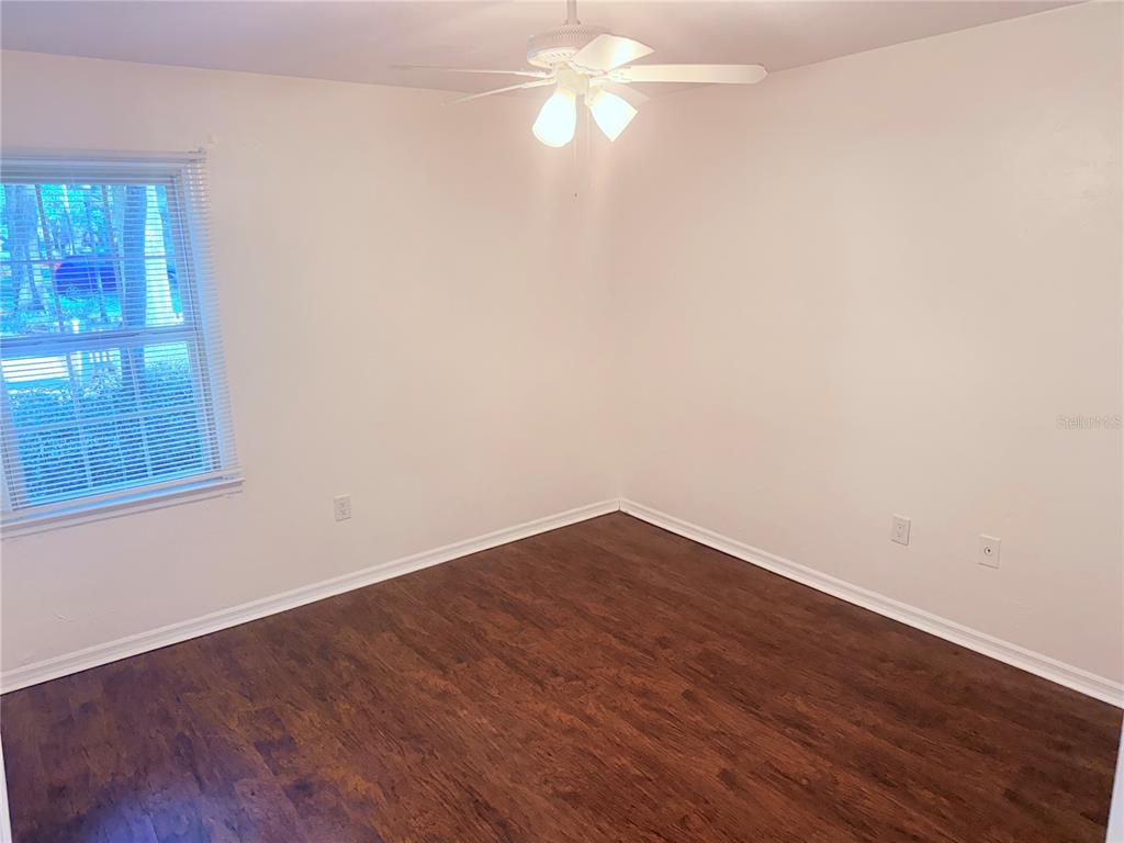 5134 Southwest 92nd Court Gainesville, FL 32608 - Photo 15 of 20 a view of empty room with wooden floor and fan
