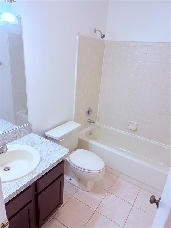 5134 Southwest 92nd Court Gainesville, FL 32608 - Photo 18 of 20 a bathroom with a granite countertop sink a toilet a mirror and a bathtub