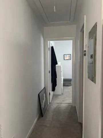 a view of a hallway with closet and wooden floor