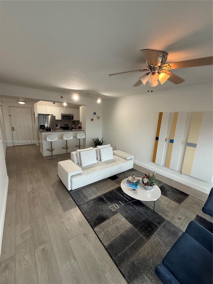 2665 Southwest 37th Avenue, Unit 1213 Miami, FL 33133 - Photo 16 of 54 a living room with furniture and a dining table with kitchen view