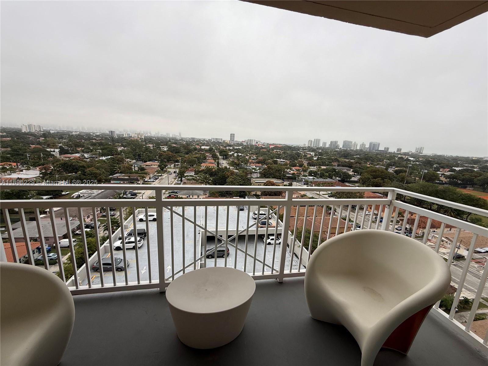 2665 Southwest 37th Avenue, Unit 1213 Miami, FL 33133 - Photo 18 of 54 a balcony with table and chairs