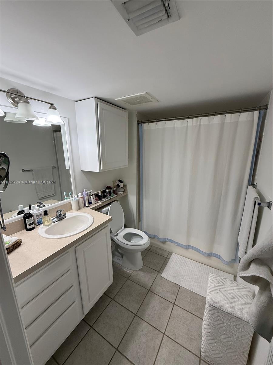 2665 Southwest 37th Avenue, Unit 1213 Miami, FL 33133 - Photo 24 of 54 a bathroom with a toilet sink and mirror