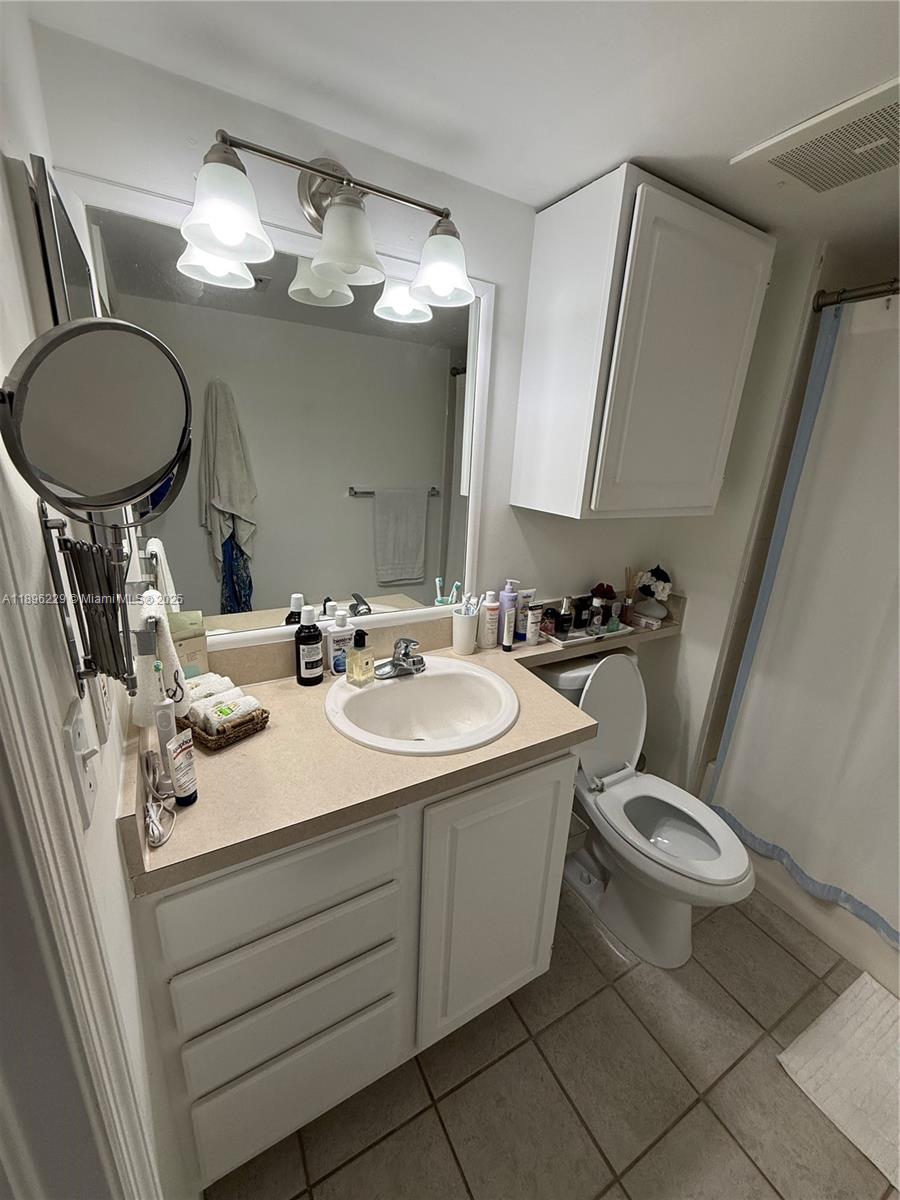 2665 Southwest 37th Avenue, Unit 1213 Miami, FL 33133 - Photo 25 of 54 a bathroom with a toilet a sink and mirror