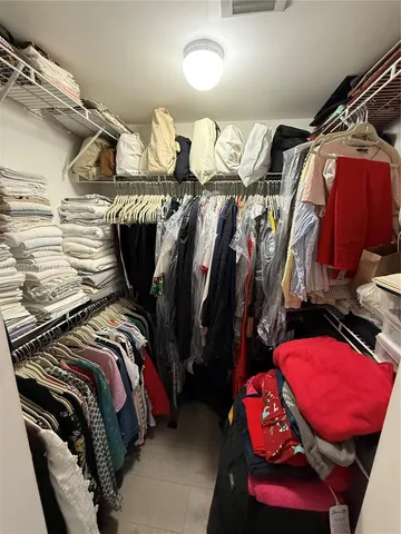 a view of walk in closet with clothes and shoes