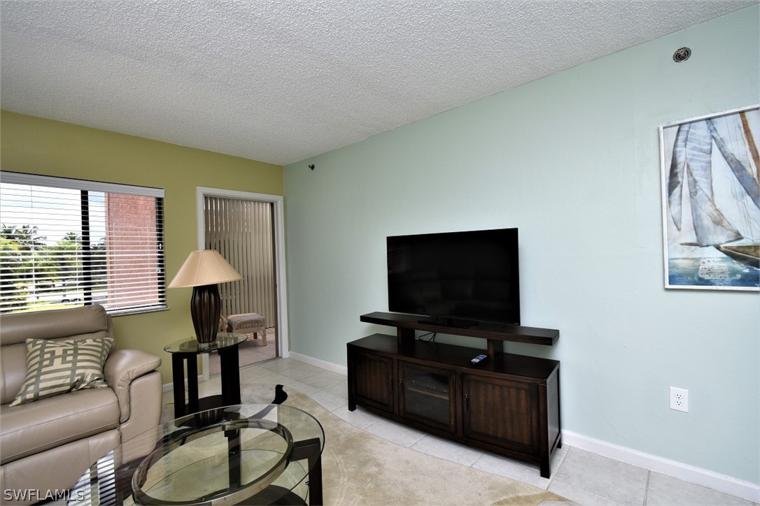 3170 Matecumbe Key Road, Unit 123 Punta Gorda, FL 33955 - Photo 11 of 25 a living room with furniture and a flat screen tv